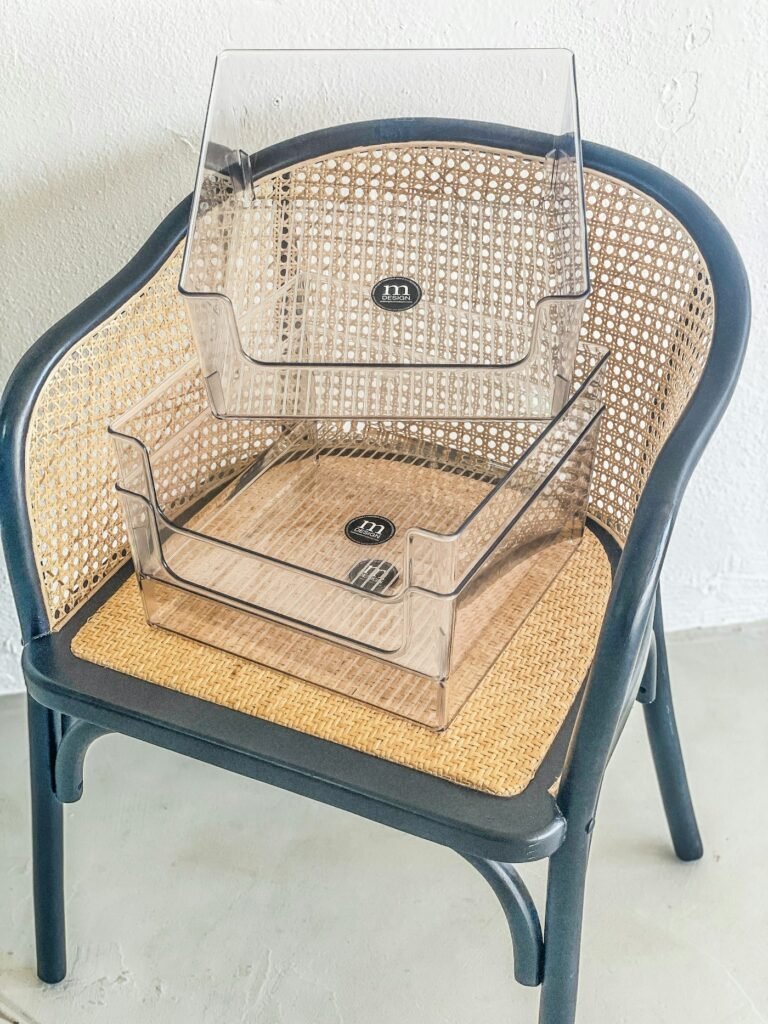 Two clear stackable organizers on a cane chair